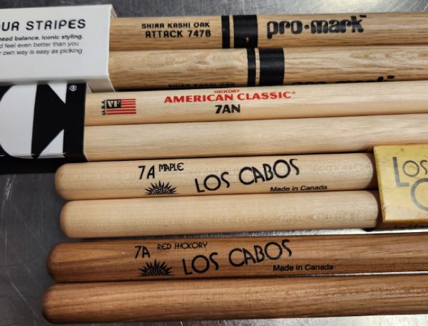 Drumsticks made of different wood types laying in a row