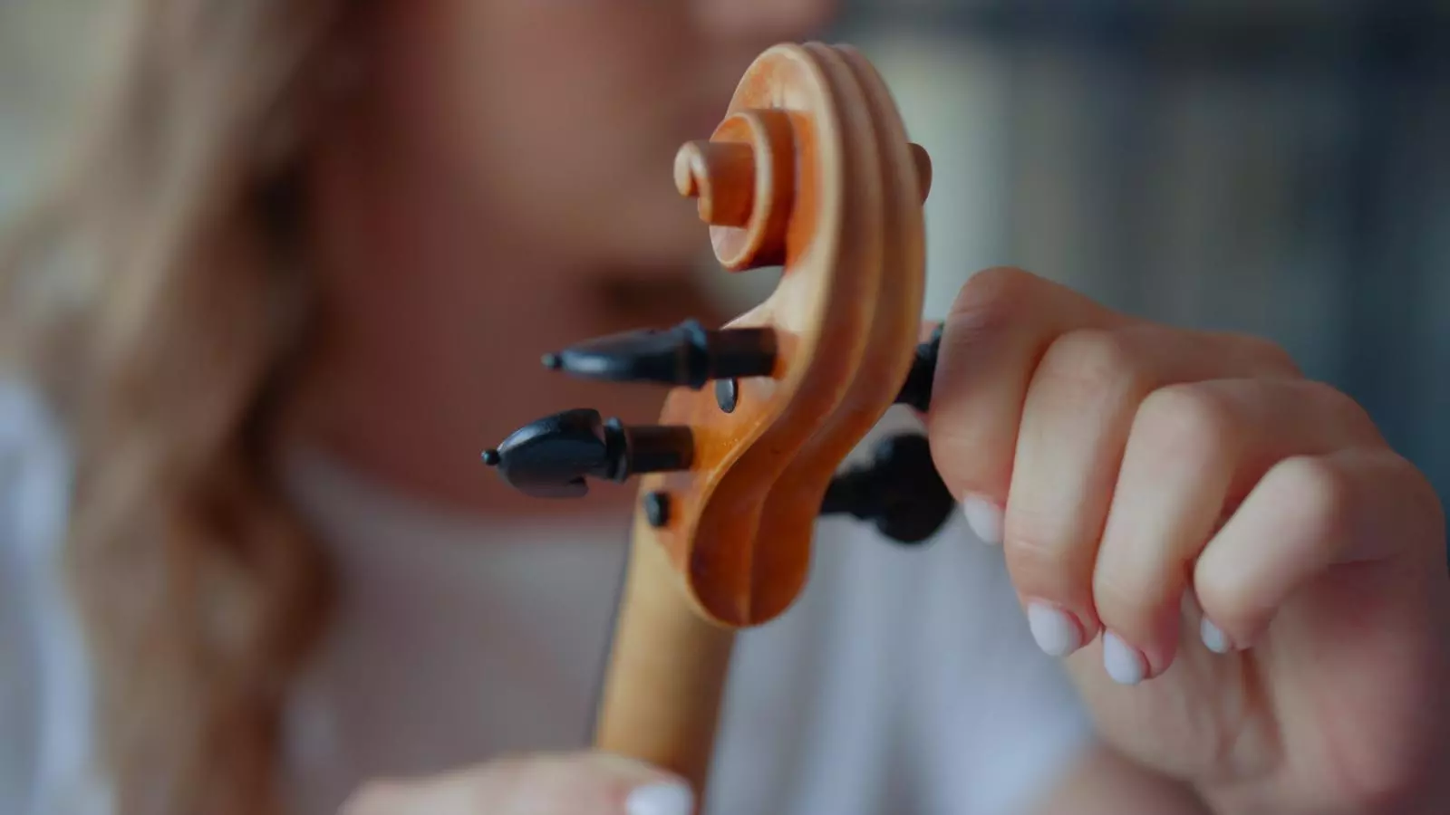 Someone turning the pegs on a violin to tune it