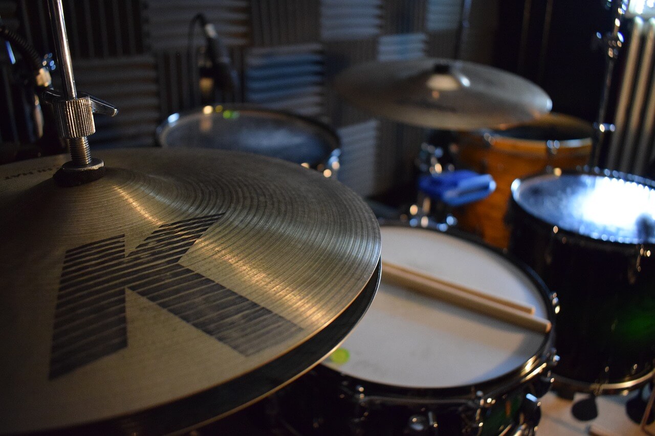 A cymbal with a logo on it and a drumset in the background