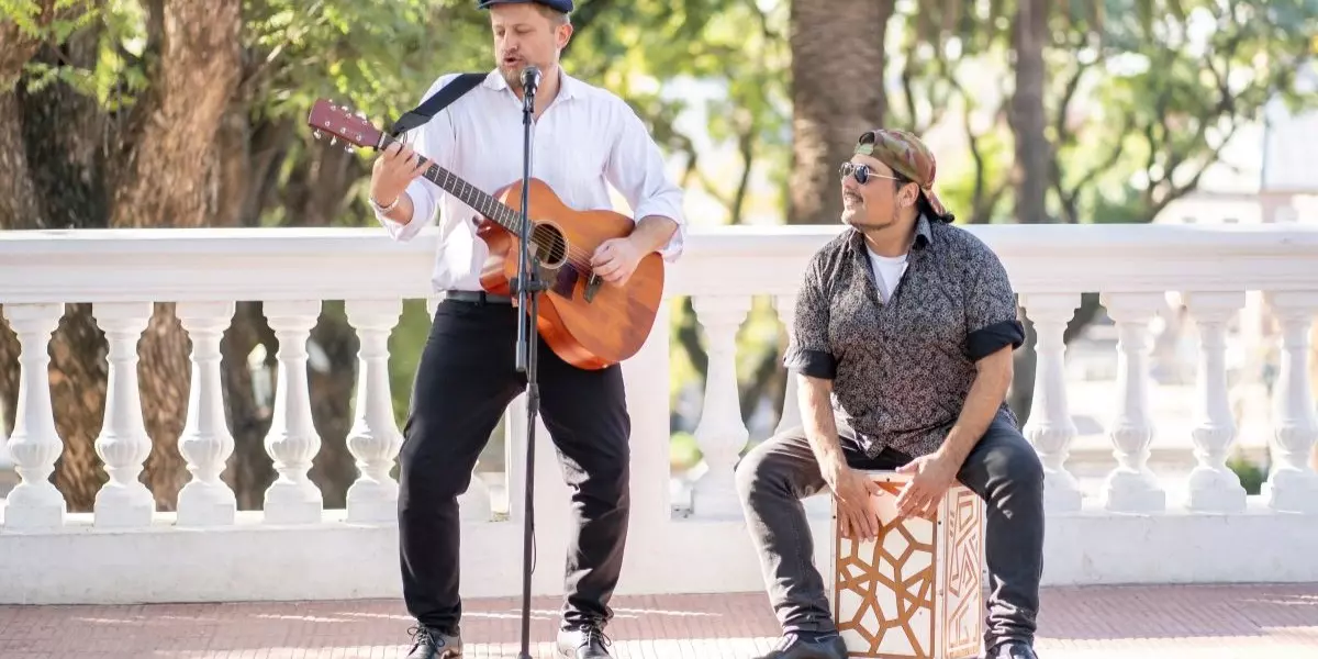 2 man band playing guitar and the cajon outdoors