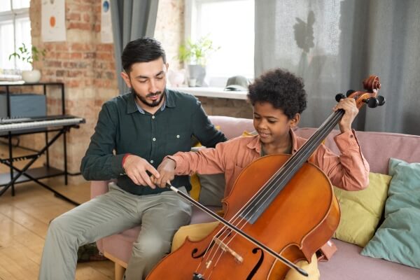 A child taking private Cello lessons with a teacher
