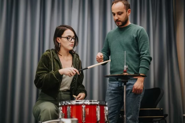 Student learning how to hold drum sticks during a drum lesson with a teacher