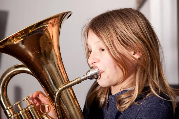 A student playing the Euphonium in his music class