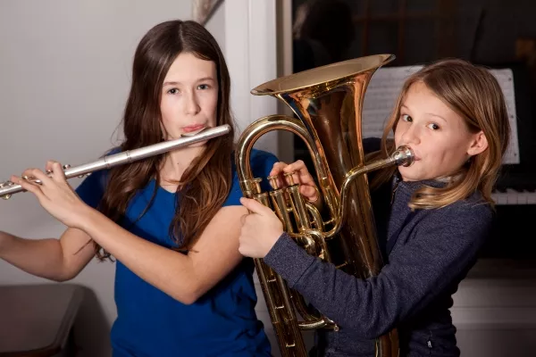 A male dressed nicely playing the Euphonium in an Orchestra
