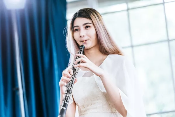 A female child playing the oboe at home