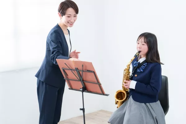 A child taking Saxophone Lessons with an instructor