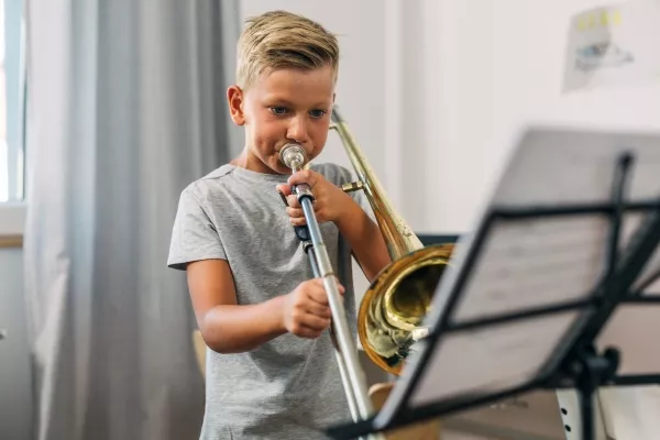 A child taking a private trombone class at home