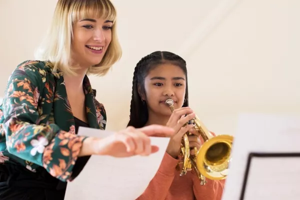 A child taking a private trumpet class with a teacher