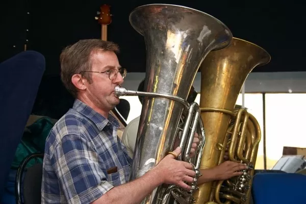 adult male playing the tuba in a band