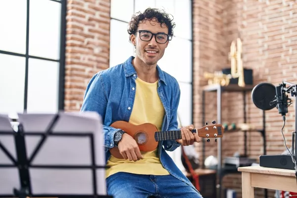 A male adult enjoying the Ukulele at home