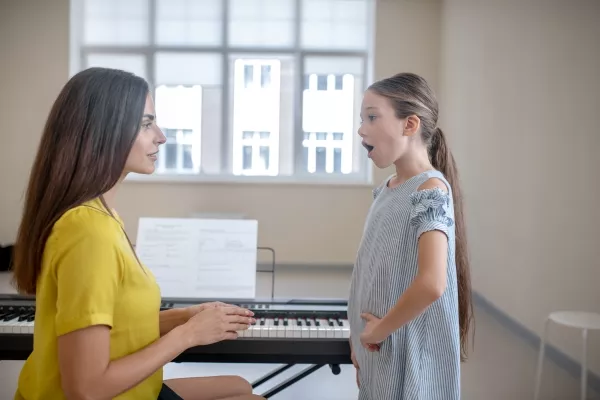 A child taking a private vocal class with a teacher